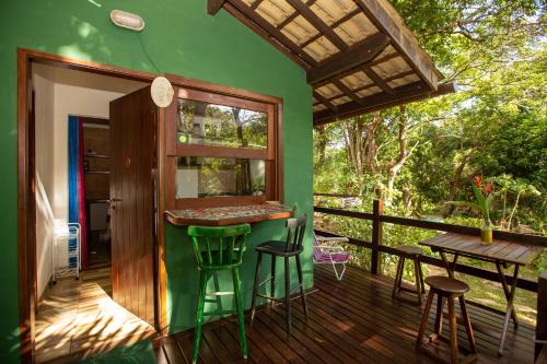 普拉亚多Recanto dos Passaros的一座带甲板酒吧的绿色房子