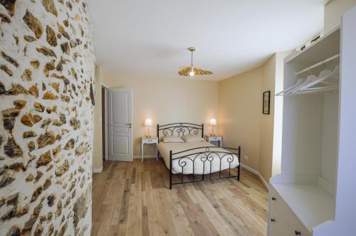 桑塞尔Le Logis du Beffroi的一间卧室设有一张床和石墙