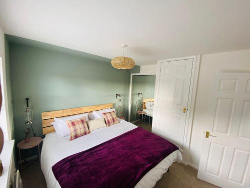 伊斯特布恩Coastal 2 bedroom maisonette with parking的一间卧室配有一张大床和紫色毯子