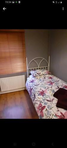 莱特肯尼Mels accomodation的一间卧室配有一张带花卉床罩的床