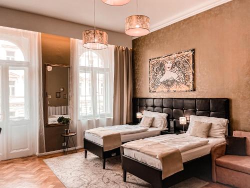 布拉格Alfons Boutique Hotel的酒店客房,设有两张床和一张沙发