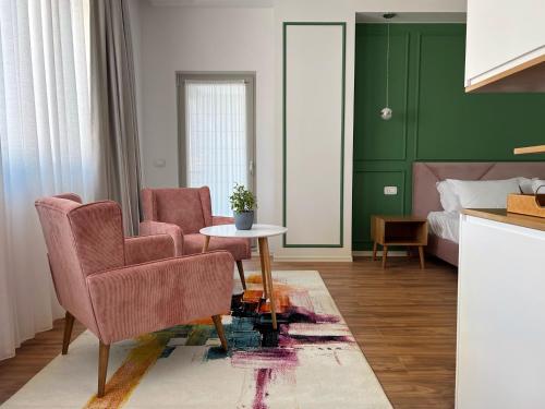 地拉那Ginger Home Tirana的客厅配有两把椅子、一张桌子和一张床