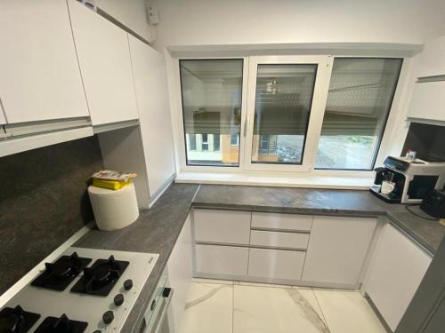 康斯坦察Bella Apartament的厨房配有白色橱柜和炉灶烤箱。