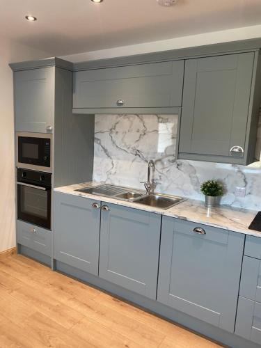 CreagorryAn Taigh Dubh- One bedroomed cottage的厨房配有灰色橱柜和水槽