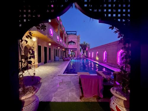 达哈布Casa d'Or Dahab PALAZZO的享有游泳池的夜间景致
