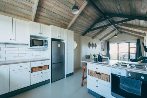 雷克赛德Lakeside Mountain Loft的厨房配有白色橱柜和黑色冰箱。
