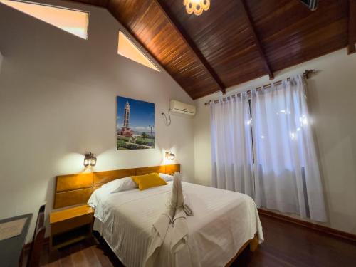 普卡尔帕Los Gavilanes Hotel的卧室配有白色的床和窗户。