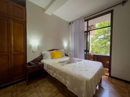 普卡尔帕Los Gavilanes Hotel的一间卧室设有一张床和一个大窗户