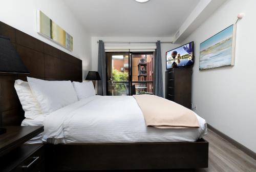 基洛纳Upgraded lakeside resort dream vacation home的卧室配有一张白色大床和一张书桌