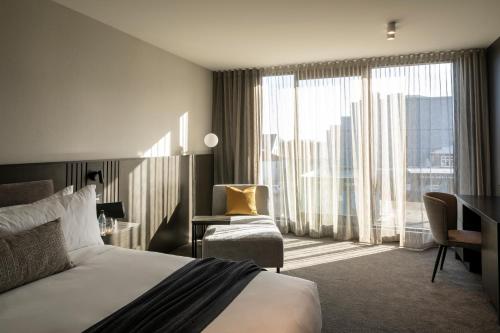 基督城The Mayfair的酒店客房设有一张床和一个大窗户
