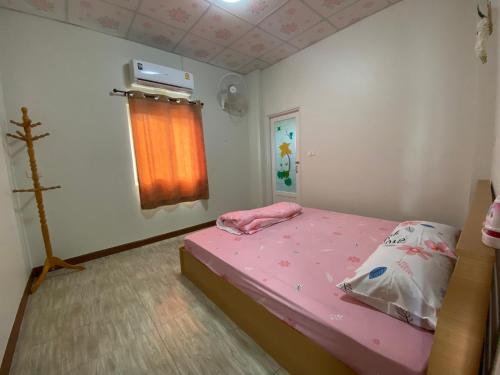 梭桃邑เพียงภูโฮมสเตย์的一间小卧室,配有粉红色的床和窗户