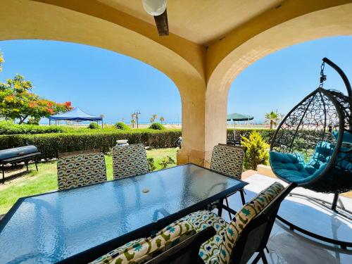 阿莱曼Lazorde Beachfront Experience的海景露台配有桌椅