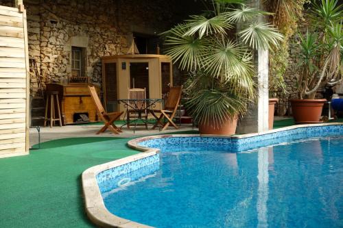 Saint-Priest-sous-Aixe穆林杜马耶度假屋的棕榈树庭院内的游泳池