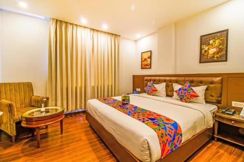 新德里Hotel Wti Airport的配有一张床和一把椅子的酒店客房