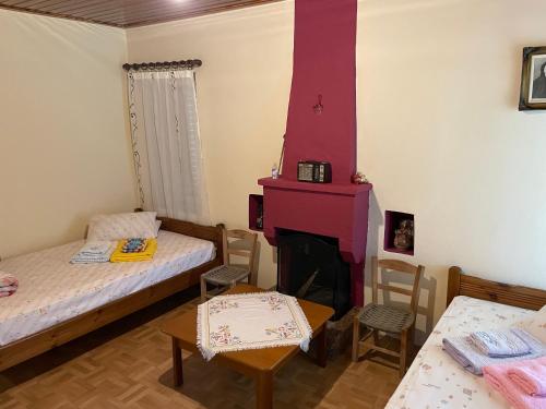 MikrospiliáVilla Lochia - Mikrospilia House的小房间设有两张床和壁炉