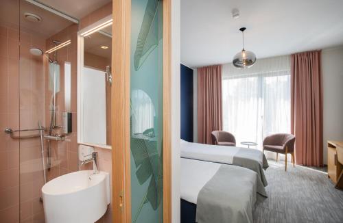 派尔努Wasa Resort Hotel, Apartments & SPA的一间医院间,配有两张床和盥洗盆