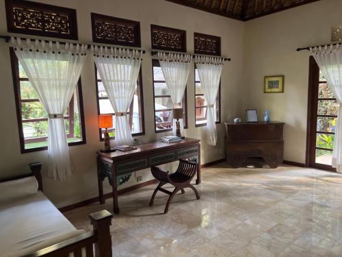 卡朗阿森Rumah Kelapa Villa Alami的窗户客房内的一张书桌