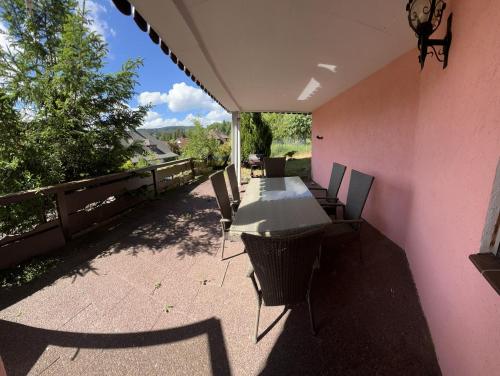 费尔德伯格Ferienhaus Samy的粉红色墙壁上配有桌椅的庭院