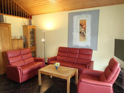 布尔哈沃Holiday Home Klipper by Interhome的一间设有红色椅子和桌子的等候室