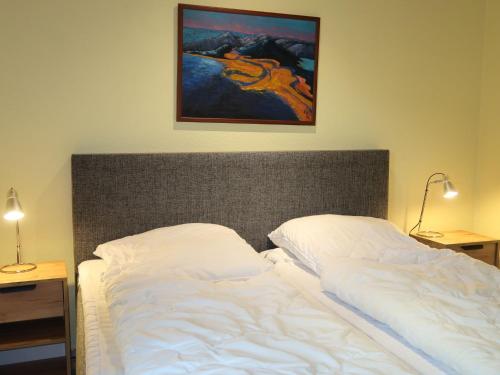 布尔哈沃Holiday Home Klipper by Interhome的卧室内的一张床铺,墙上有绘画作品