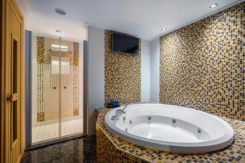 科纳克勒Bera Alanya Hotel - Halal All Inclusive的大型浴室设有浴缸和淋浴。
