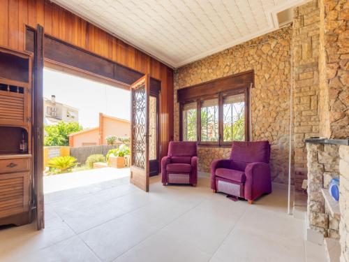 托里代巴拉Holiday Home Lleida by Interhome的石墙间,配有两把紫色椅子