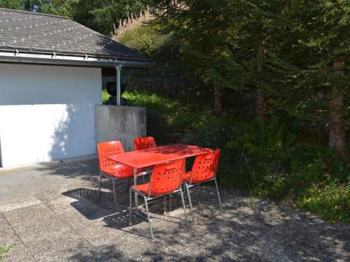 格施塔德Apartment Arduus by Interhome的露台上配有一张红色的桌子和四把椅子