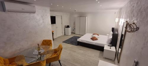 维纳斯Brateș Greaca的一间卧室配有一张床和一张玻璃桌子及椅子