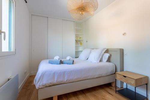 拉特斯特德布赫Pyla Plage - appartement vue mer - Perle(o)的卧室配有带蓝色枕头的大型白色床