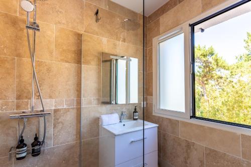 拉特斯特德布赫Pyla Plage - appartement vue mer - Perle(o)的一间带水槽和淋浴的浴室以及窗户。