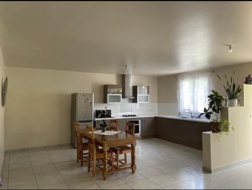 蒙蒂尼亚克Au pied de Lascaux的厨房配有桌椅和冰箱。
