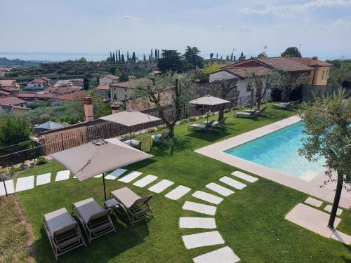 卡瓦伊翁韦罗内塞Il cantuccio sul Garda - Relais di charme的房屋旁的游泳池配有椅子和遮阳伞