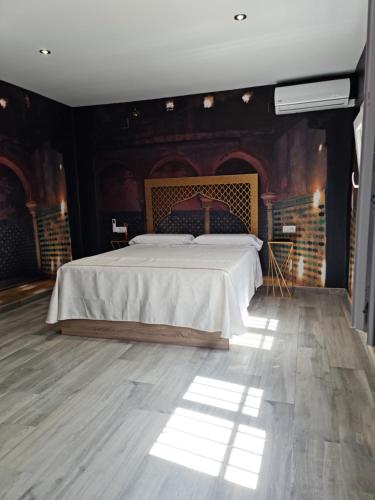 韦尔瓦Apartamento Luxury Suite Huelva Zona Centro的一间卧室设有一张床和砖墙