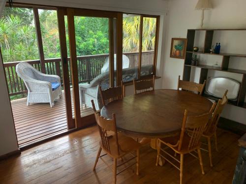 LobambaJackalberry Cottage的一间带桌椅的用餐室和一个阳台