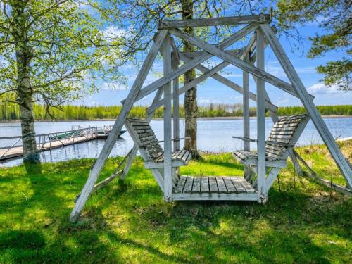 伊萨尔米Holiday Home Tuliniemi by Interhome的湖上秋千桥上的两把椅子