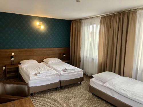 什奇特诺Hotel Krystyna的酒店客房设有两张床和绿色的墙壁。