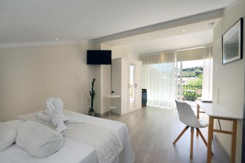 贝尼曼特利Nasilvana Hotel & Spa Adults Only的白色卧室配有白色的床和书桌