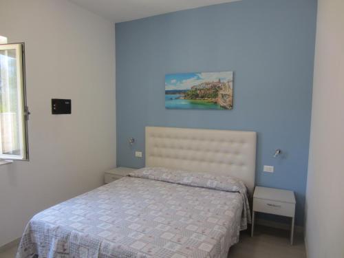 维耶斯泰Villa Elisa的卧室配有一张床,墙上挂有绘画作品