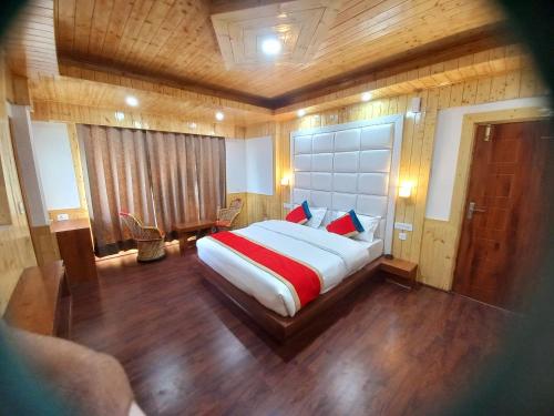 西姆拉Humble Holiday Inn Kufri Simla的一间卧室配有一张带红色和蓝色枕头的大床