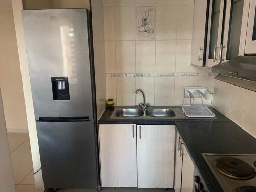 比勒陀利亚A Cozy one bed apartment in Pretoria Central的厨房配有不锈钢冰箱和水槽