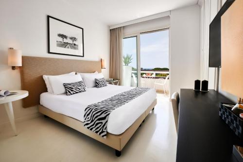 马里纳-迪-皮特拉桑塔蒙迪艾尔度假温泉酒店的酒店客房设有一张床和一个阳台。