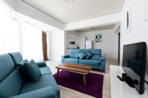 马马亚White Tower Mamaia Apartament Privat 503的客厅配有蓝色的沙发和桌子