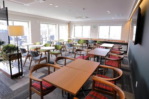 川越Hatago COEDOYA的用餐室设有桌椅和窗户。