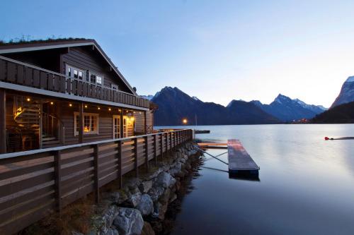 SæbøSagafjord Hotel - by Classic Norway Hotels的山 ⁇ 湖上的小屋
