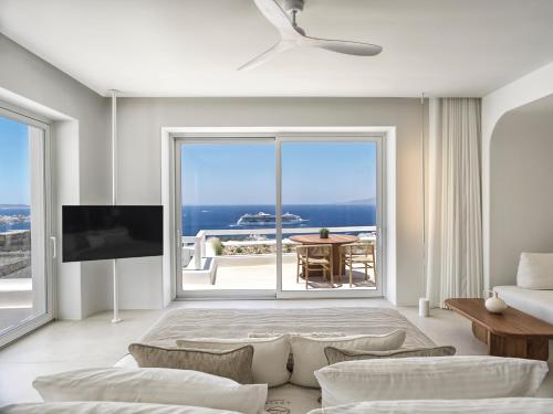 米克诺斯城Lovia Mykonos的带沙发和大窗户的客厅