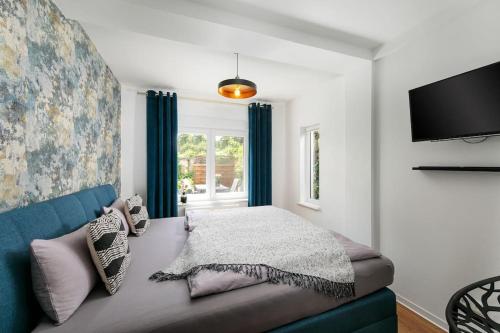 波茨坦charmantes Townhaus mit Garten, W-LAN & Netflix的一间卧室配有蓝色的沙发和一台电视机