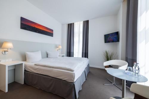 吕贝克Hotel KO15的酒店客房配有一张床铺和一张桌子。