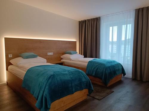 姆拉哥沃Apartamenty Polonia Mrągowo的酒店客房设有两张床和窗户。