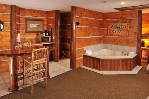 罗斯切尔德Stoney Creek Hotel Wausau - Rothschild的带浴缸、水槽和桌子的浴室