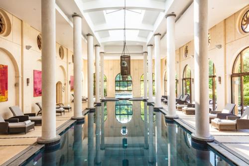 图雷特特雷布兰克Spa高尔夫度假酒店的一座带柱子和椅子的建筑中的游泳池